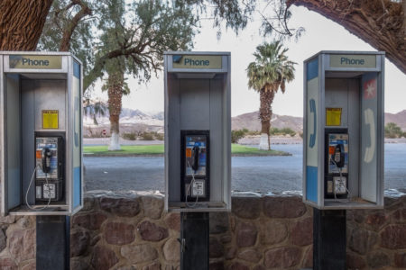 Pay telephones with palm trees in background in Death Valley California