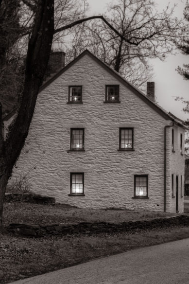 Candles in windows of house at night in Harpers Ferry