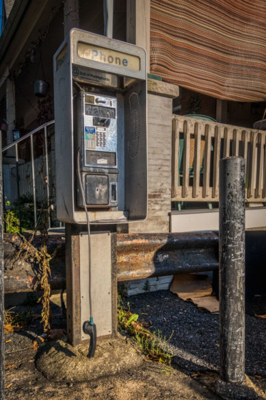 Broken pay telephone next to house in Lancaster Pennsylvania